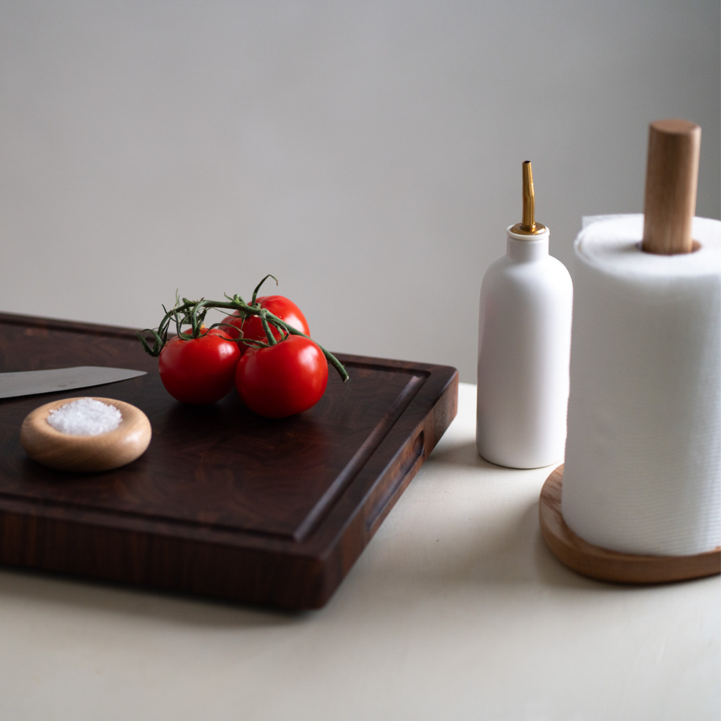 Styled shot of a chopping board, salt dish and paper towel stand