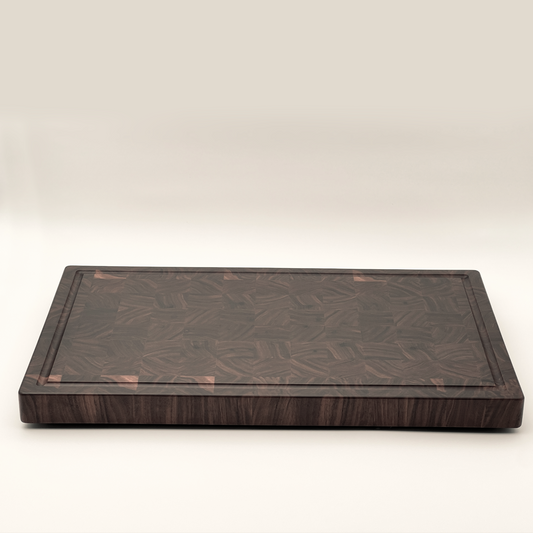 A brown wooden butcher's block with a smooth surface and visible grain patterns, displayed against a plain background.