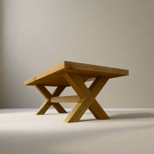 Wooden coffee table with X-shaped legs on a plain background
