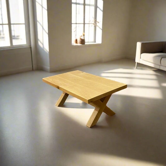 Wooden coffee table in a bright room with large windows and a sofa.