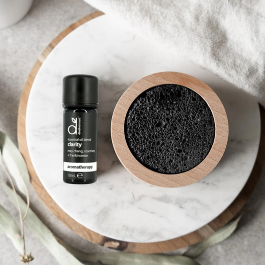 Lava rock diffuser and essential oil blend on a marble surface