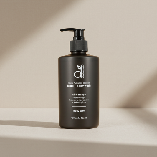 Black bottle of hand and body wash with pump on a beige background