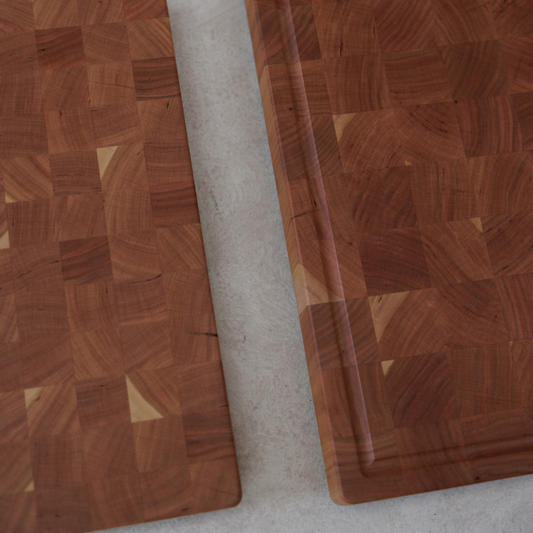 Two wooden chopping boards on a stone benchtop.
