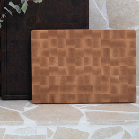 Wooden cutting board with a checkered pattern on a stone surface