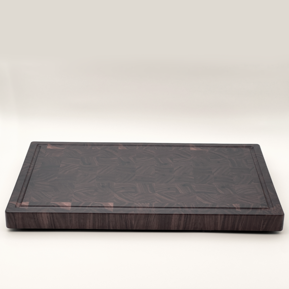 Walnut end-grain chopping board on a white background