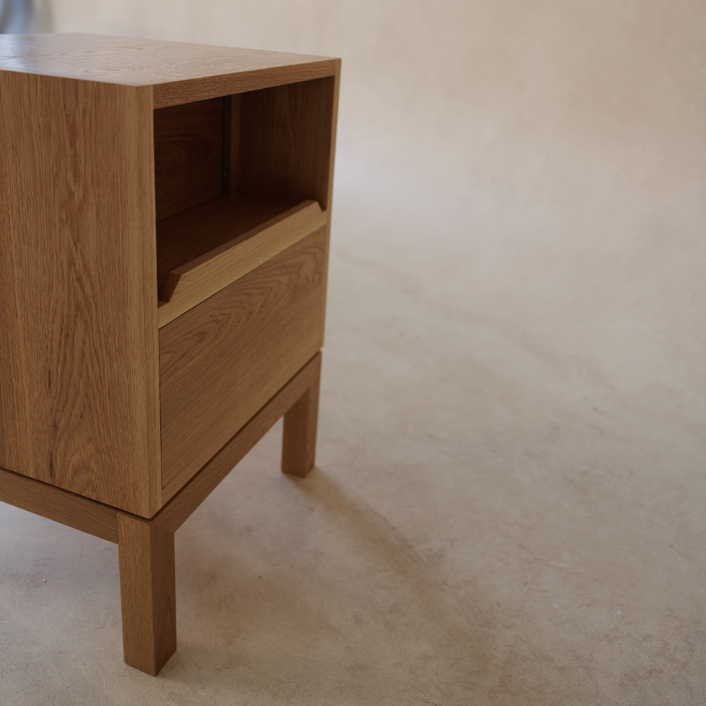 Back of a wooden side table with platform for power cables