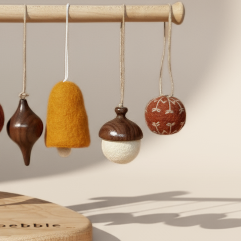 Hand turned walnut and white felt acorn ornament with jute loop hanging with an assortment of Christmas decorations