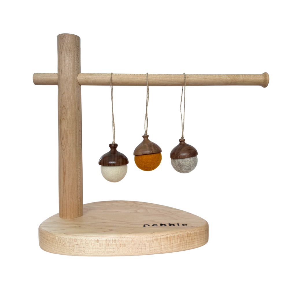 Three hand turned walnut and felt acorn ornaments with jute loop hanging from a wooden stand. Australian Made natural Christmas decoration for slow living