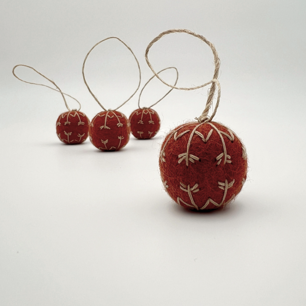 Red felt ornaments with string on a white background