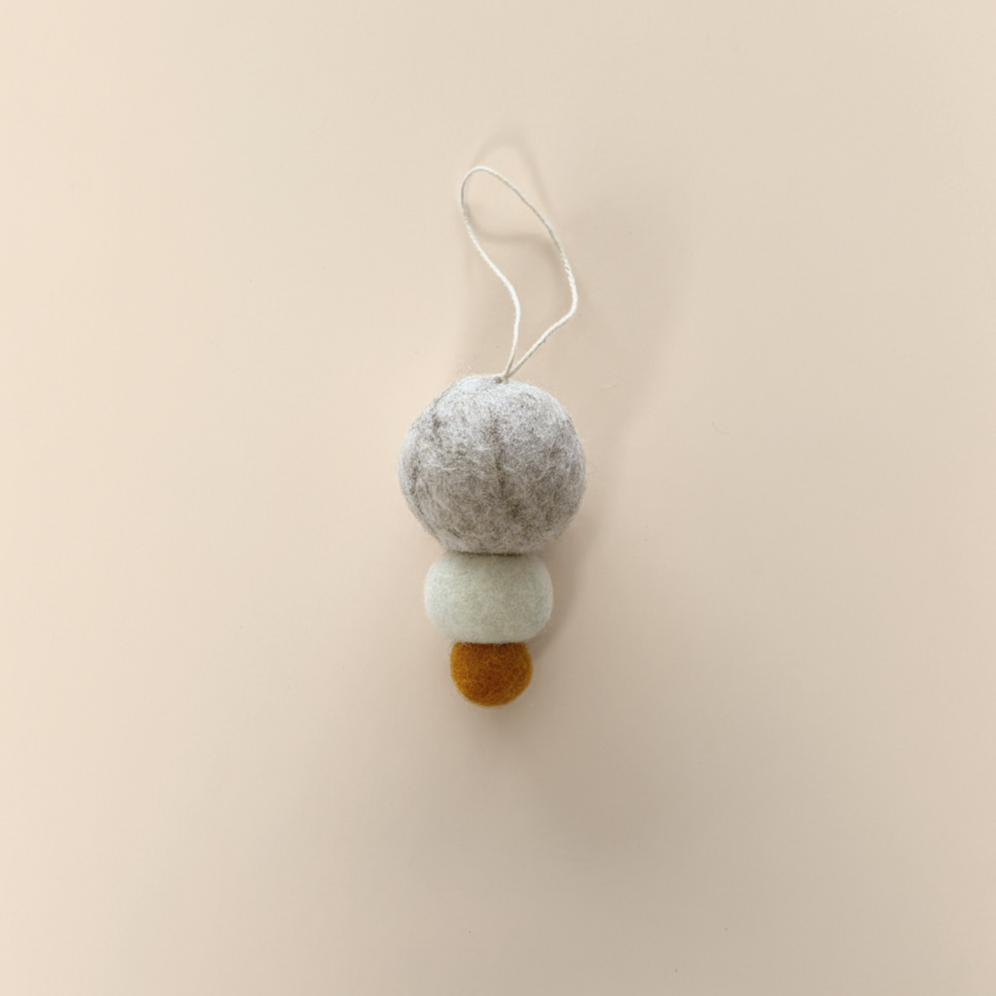 Pebble Studio felt Christmas decoration on a beige background