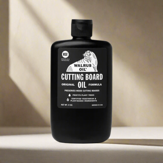 Black bottle of Walrus Oil Cutting Board Oil on a light background