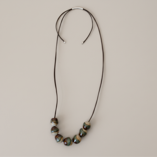 Necklace with ceramic beads on a beige background