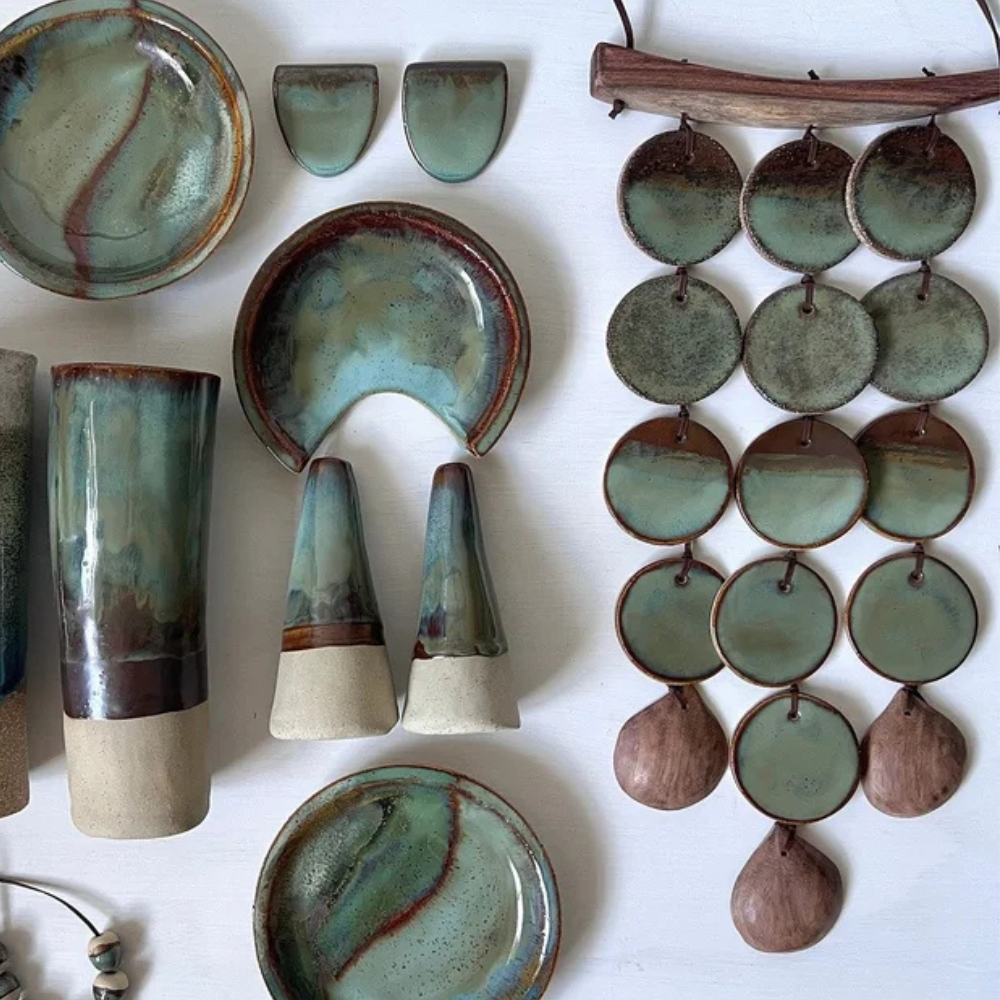Collection of ceramic items including bowls, vases, and a hanging wall art on a white background.