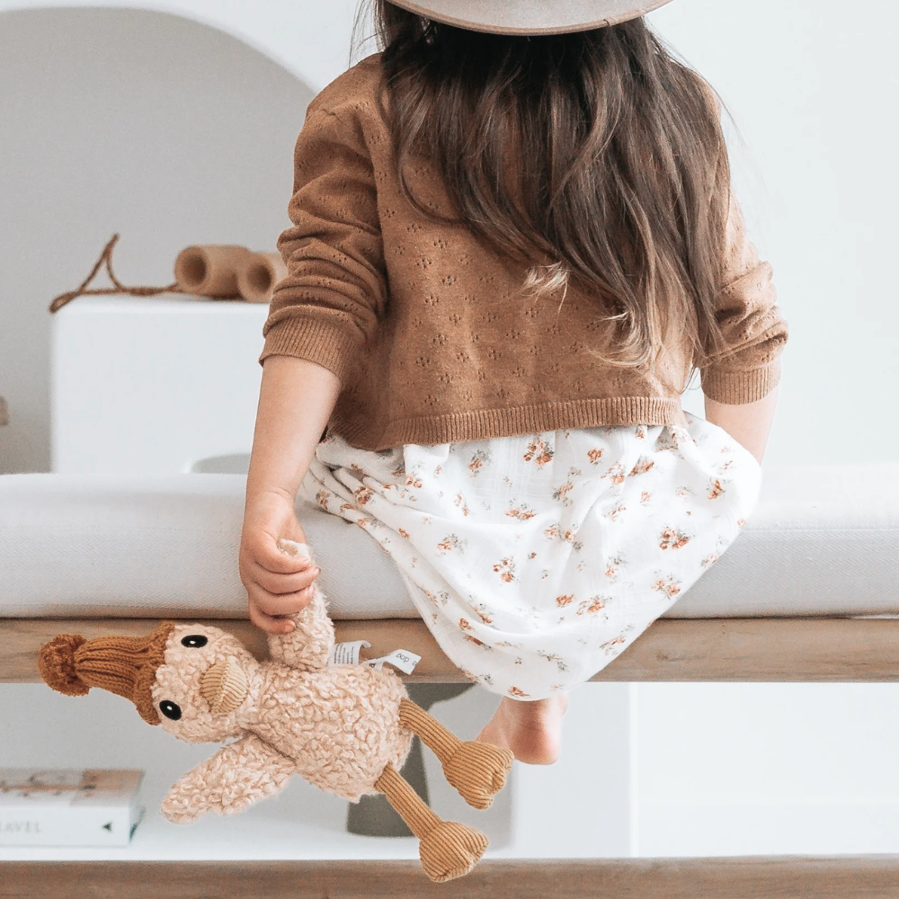 Child holding a plush toy in a home setting