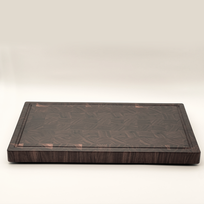 A brown wooden butcher's block with a smooth surface and visible grain patterns, displayed against a plain background.