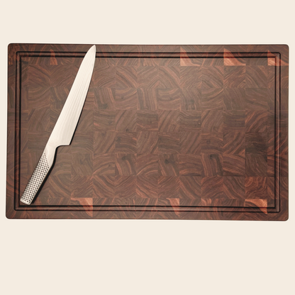 Pebble Studio Walnut chopping board with knife sitting on top