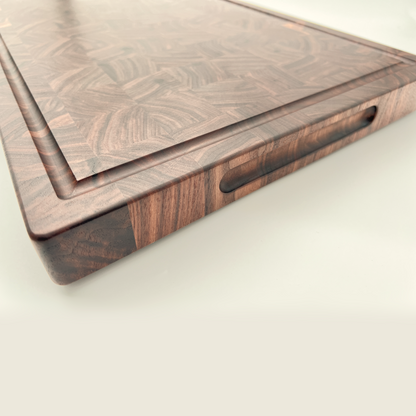 Side of a Walnut chopping board showing the handles and juice groove