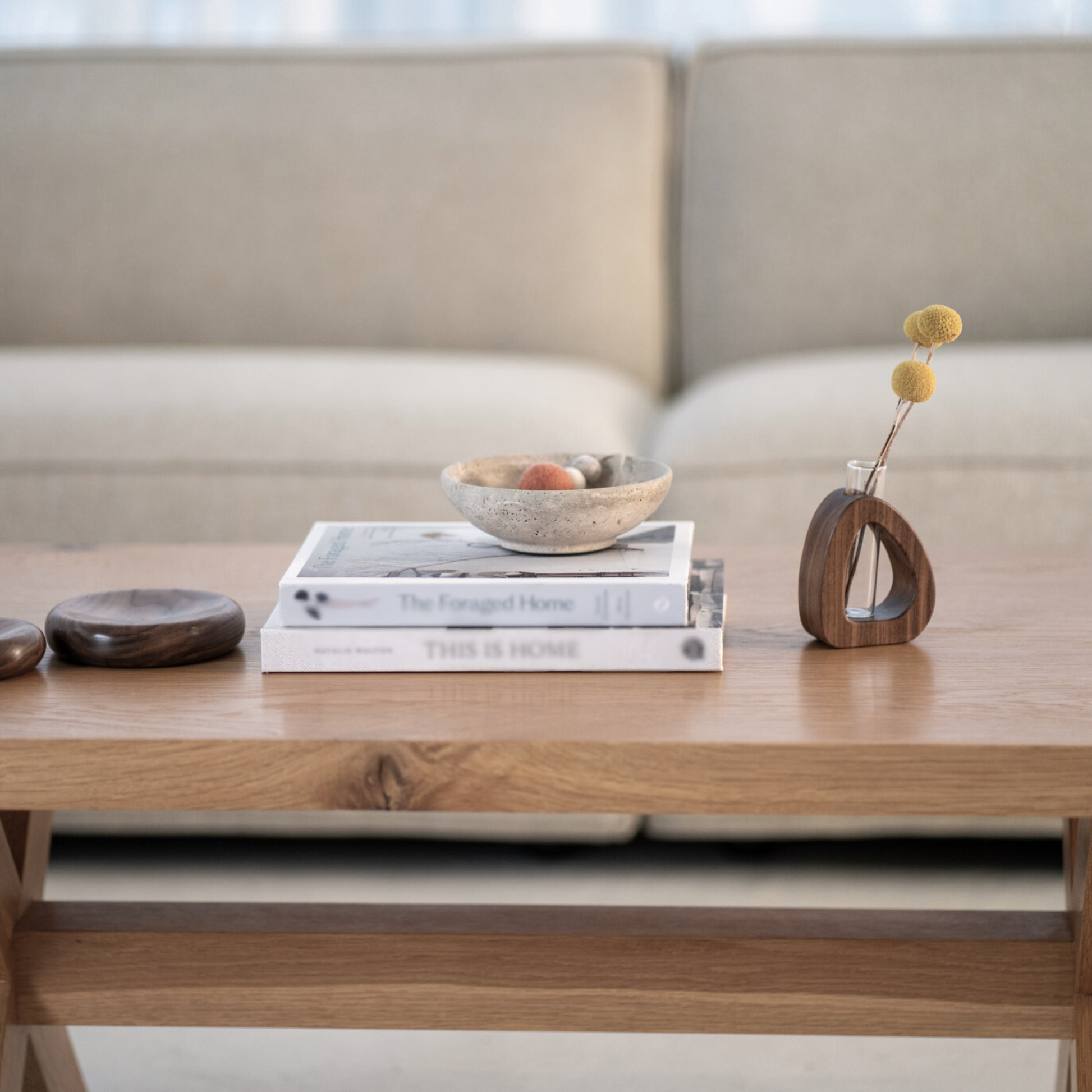 Wooden coffee table with decorative items including books, a bowl, and a vase.
