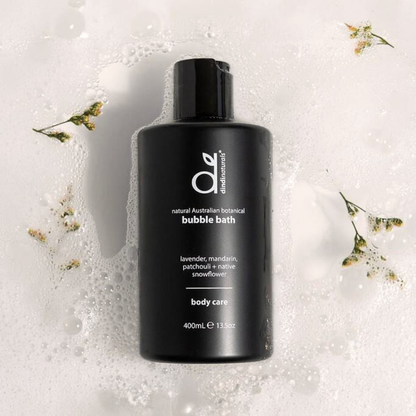 Black bottle of bubble bath with brand logo on a textured white background