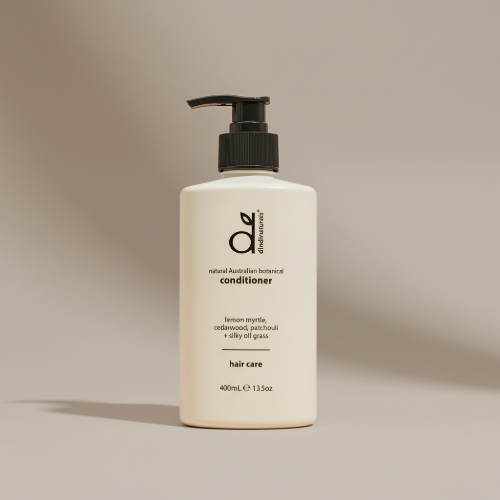 White conditioner bottle with black pump on a beige background