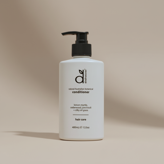 White bottle of conditioner with black pump on a beige background