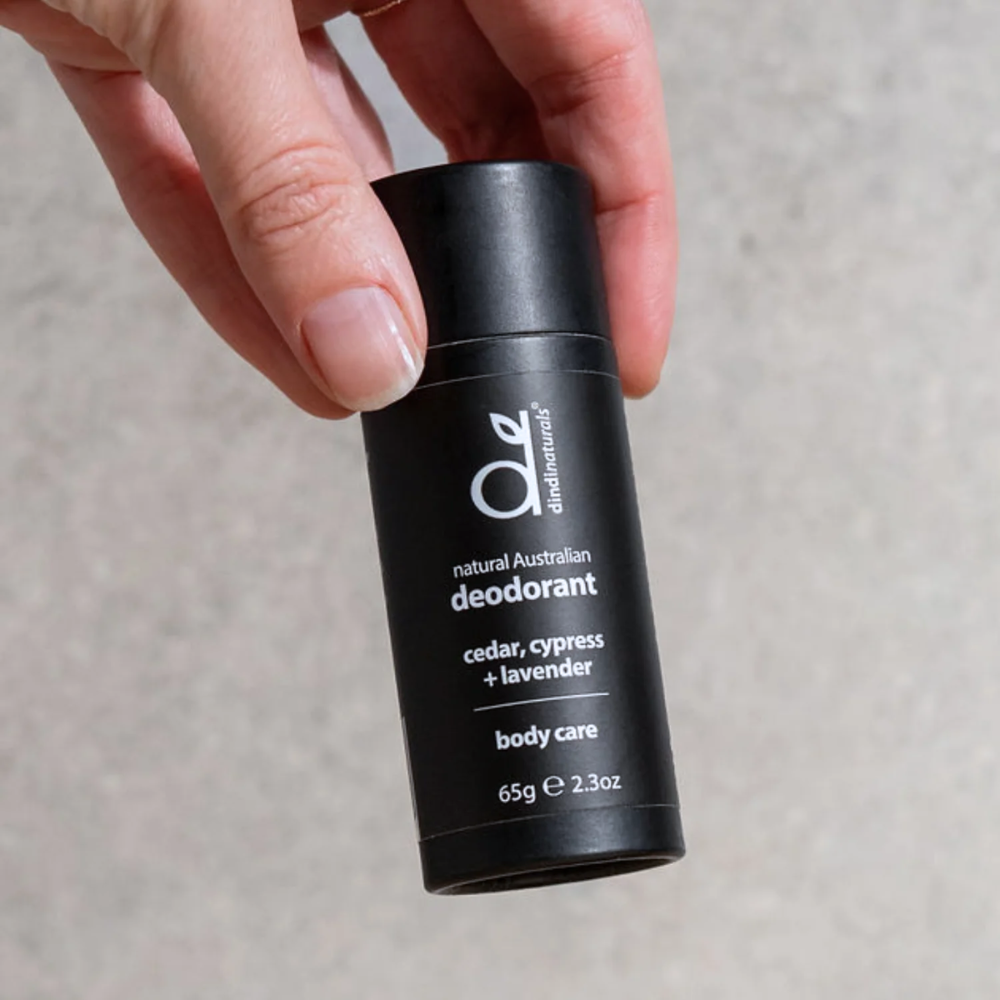 Handing holding a tube of natural deodorant