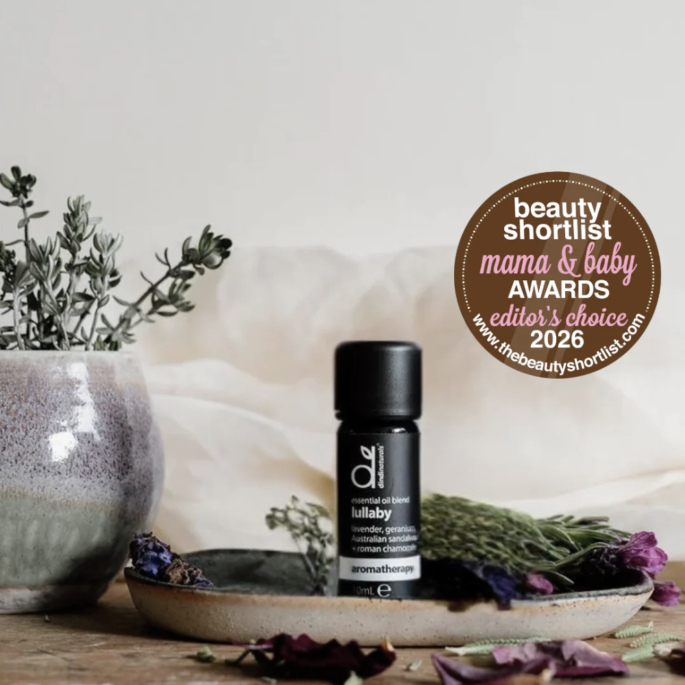 Essential Oil bottle on a wooden surface with decorative elements and an award badge.