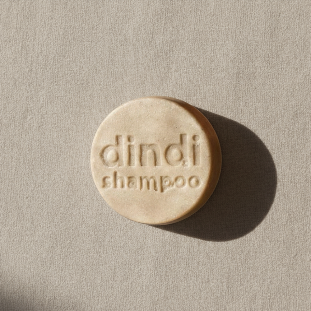 Dindi Naturals shampoo bar with 'dindi' branding on a beige background