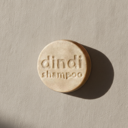 Dindi Naturals shampoo bar with 'dindi' branding on a beige background