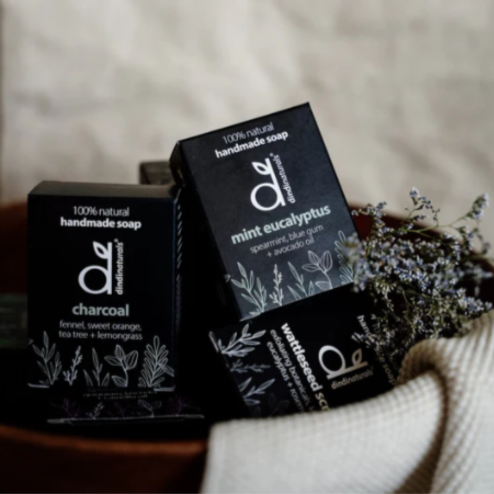Three boxes of handmade soap with visible branding on a neutral background