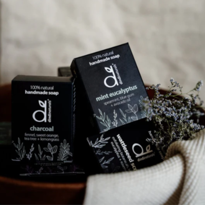 Three boxes of handmade soap with visible branding on a neutral background