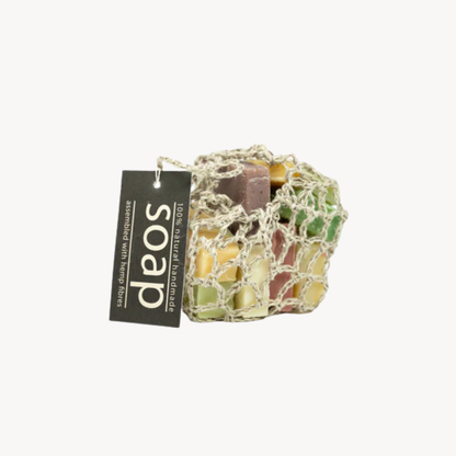 Assorted soap bars in a hemp bag with a 'soap' tag on a white background