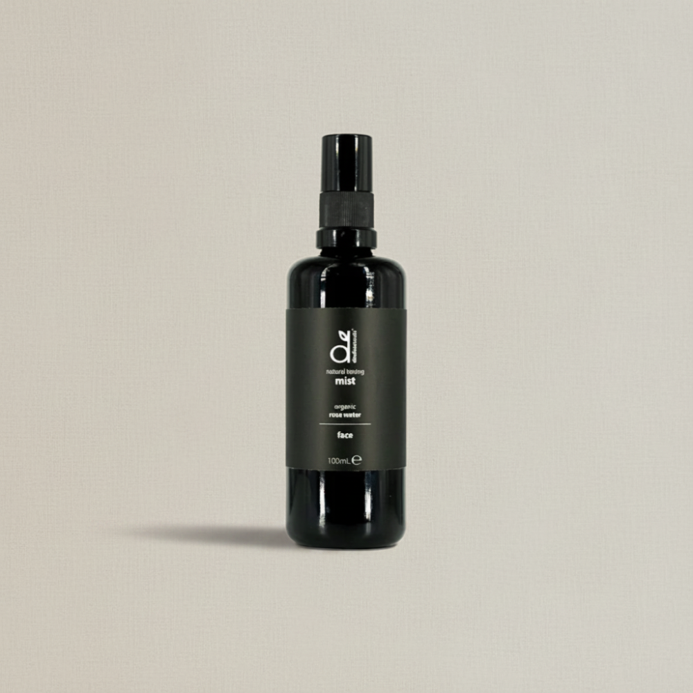 Black spray bottle of Dindi Naturals Rose Toning Spray on a beige background