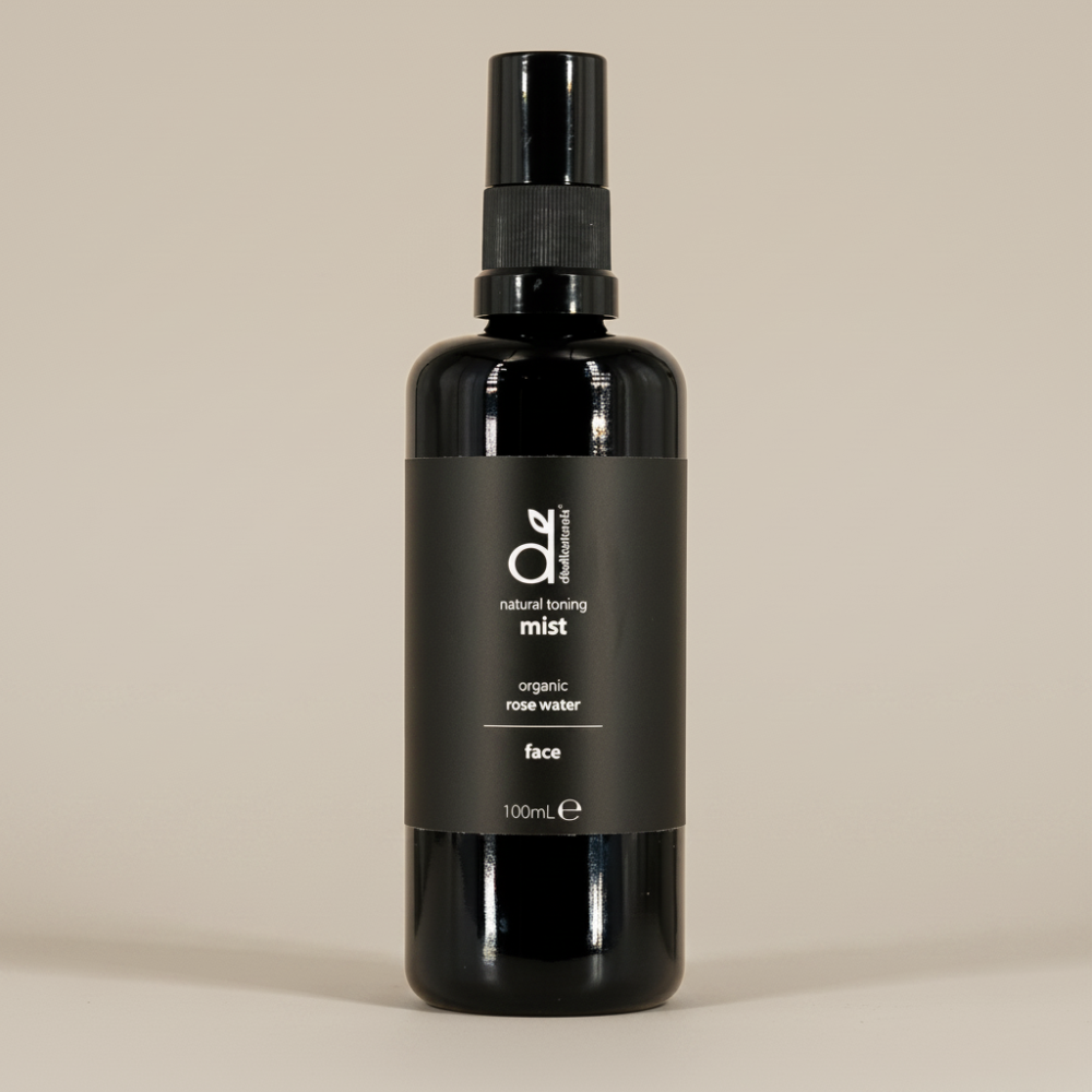 Black bottle of Dindi Naturals organic rose water face mist on a beige background