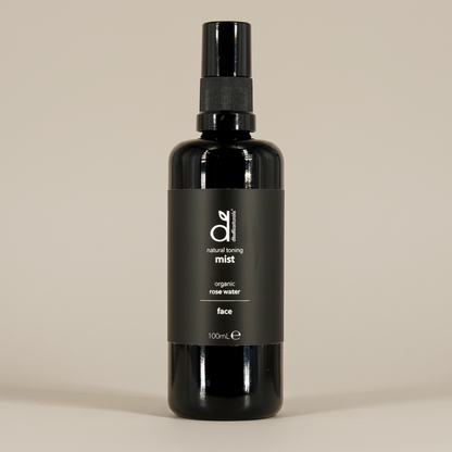 Black bottle of Dindi Naturals organic rose water face mist on a beige background