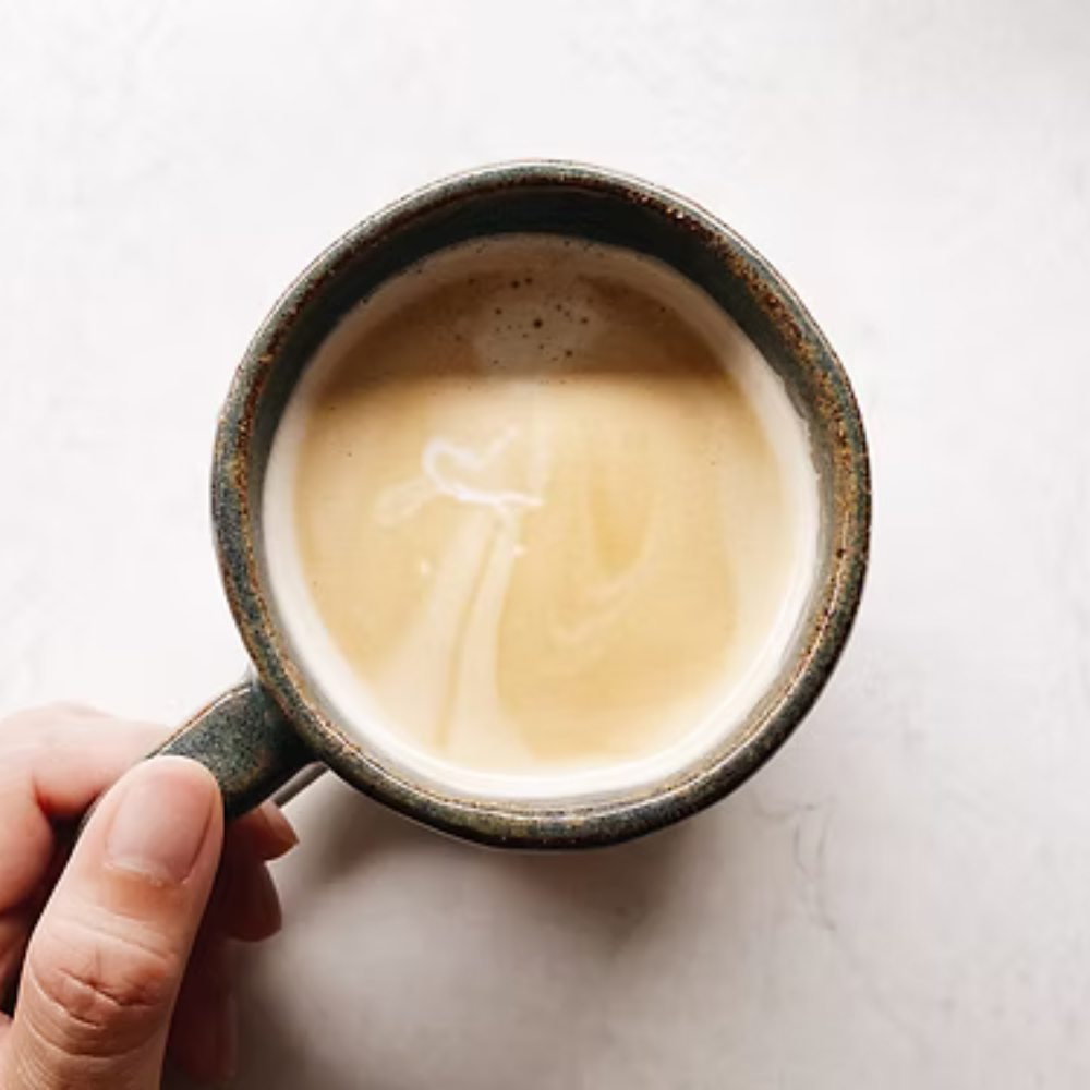 Hand holding a mug of coffee with a white background