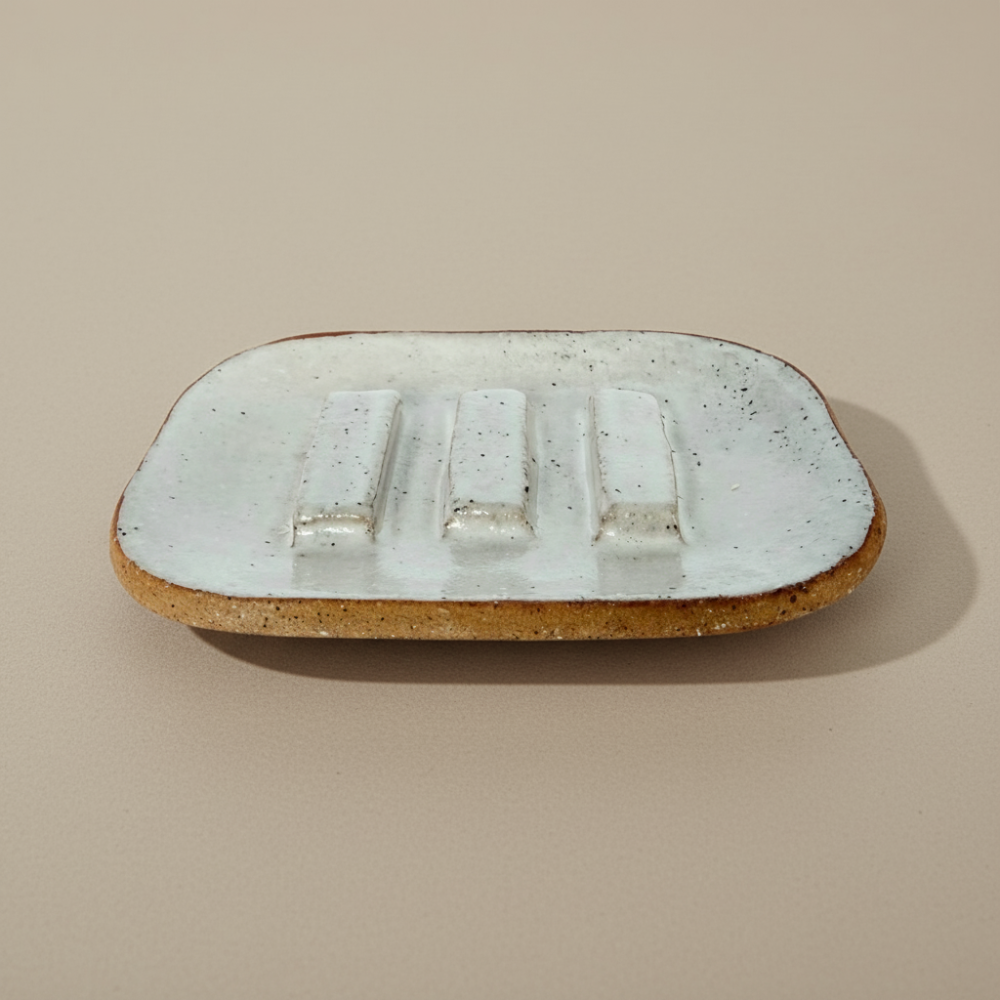 Rectangular ceramic soap dish with textured surface on a beige background