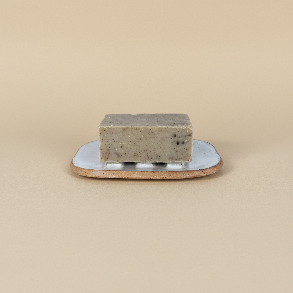 Bar of soap on a ceramic plate against a beige background
