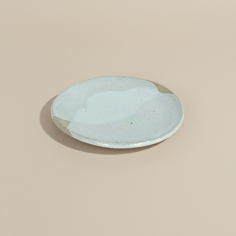 Light colour ceramic plate on a beige background