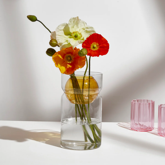 Fazeek clear glass vase with amber sphere insert holding flowers on a light background
