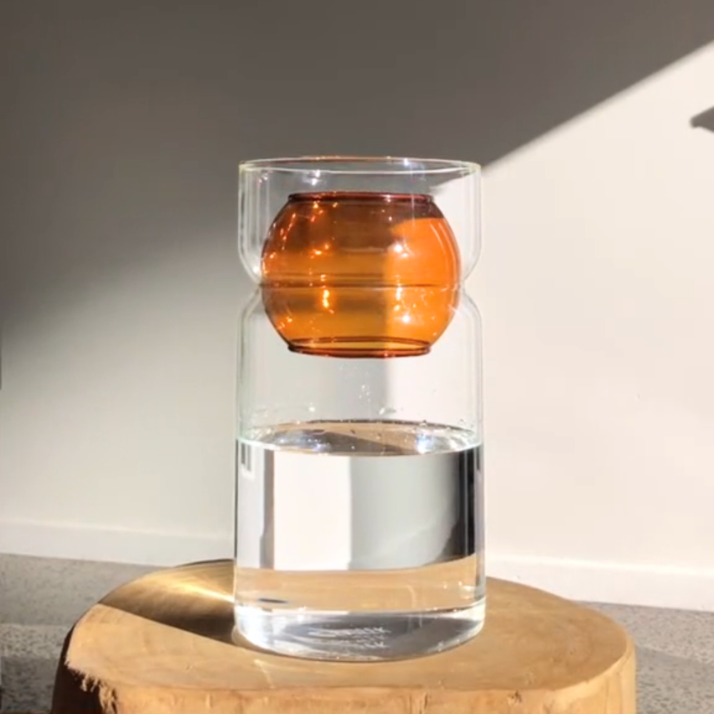 Fazeek clear glass vase with amber sphere insert on a light background