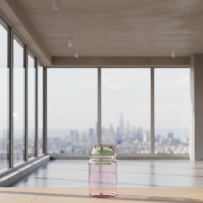 Fazeek pink glass vase with green sphere insert sitting on a wood bench in a living room