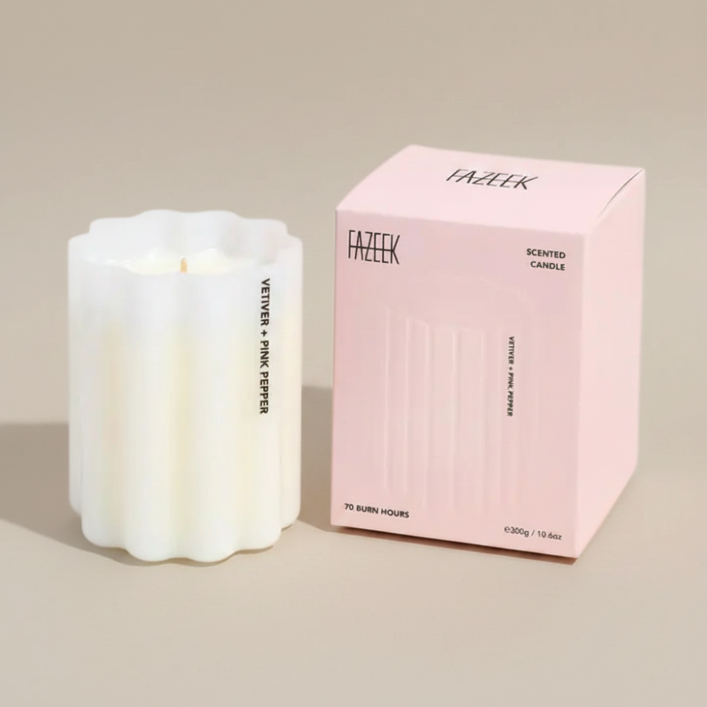 Fazeek Wave Candle in Vetiver and Pink Pepper Scent sitting next to a pink canlde box on a beige background