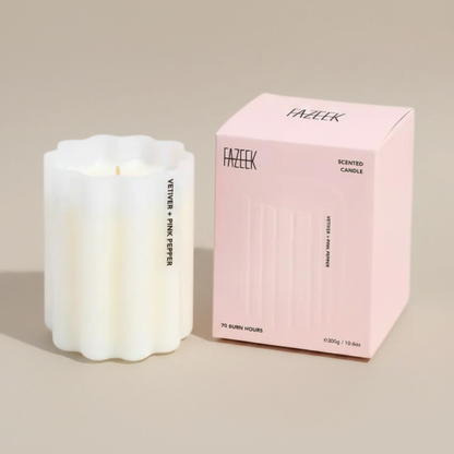 Fazeek Wave Candle in Vetiver and Pink Pepper Scent sitting next to a pink canlde box on a beige background