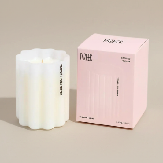 Fazeek Wave Candle in Vetiver and Pink Pepper Scent sitting next to a pink canlde box on a beige background