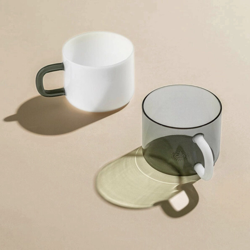 Two glass mugs on a beige surface with a neutral background