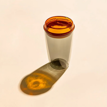 Grey glass cup with orange lid. Can be used for tea, coffee or other beverages