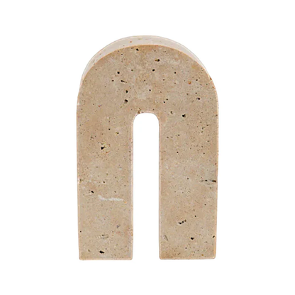 Beige arch-shaped travertine sculpture on a white background