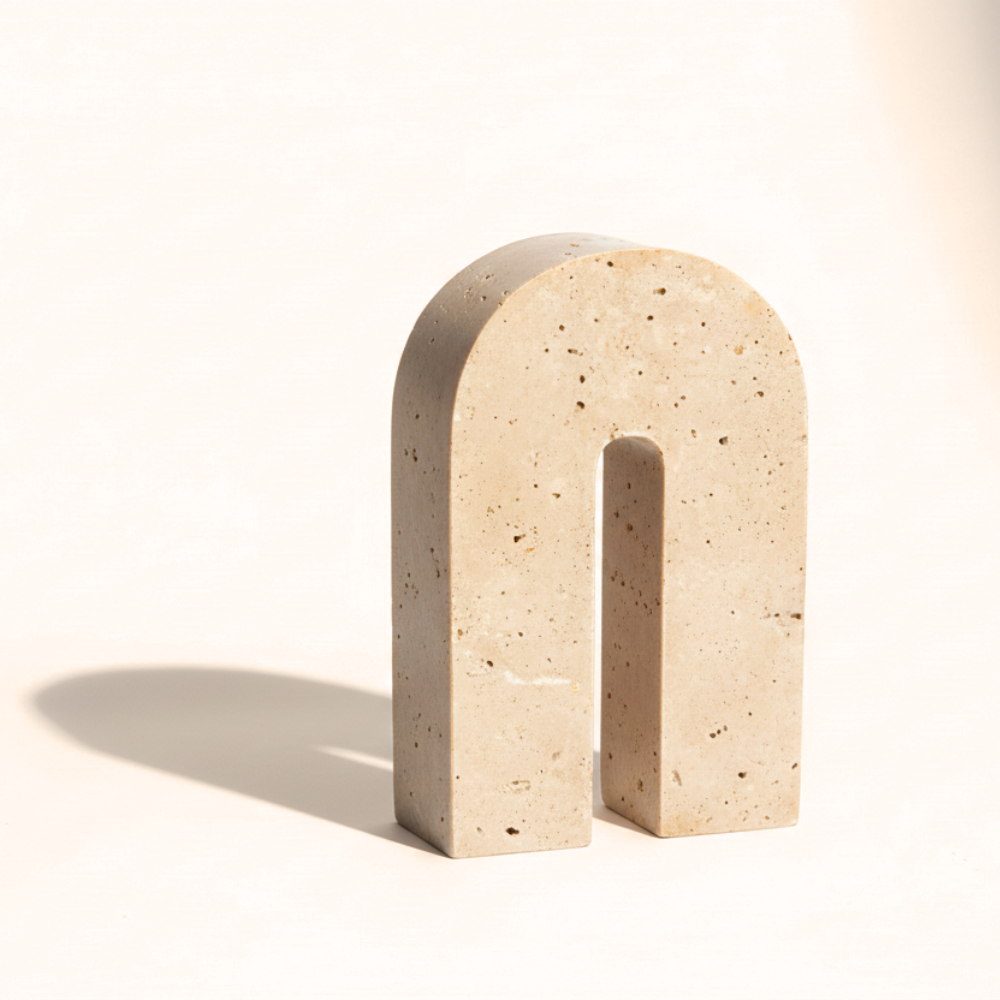 Beige stone arch sculpture on a white background