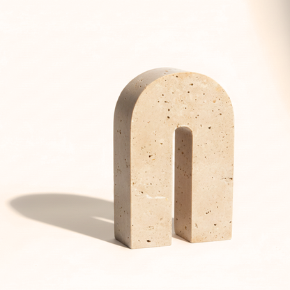 Beige stone arch sculpture on a white background